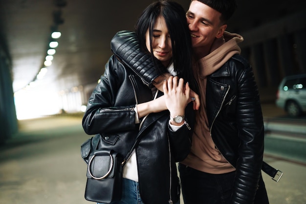 Young couple in love hug each other and kisses in underground crossing Love story