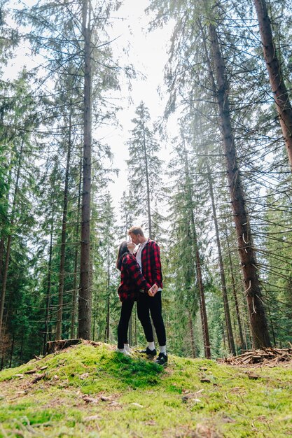 Young couple in love hugging and kissing in the woods