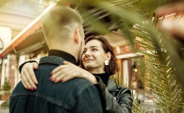 Photo young couple in love hugs and spend time together in the city against the backdrop of urban architecture.