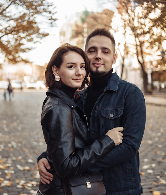 Young couple in love hugs and spend time together in the city against the backdrop of urban architecture.