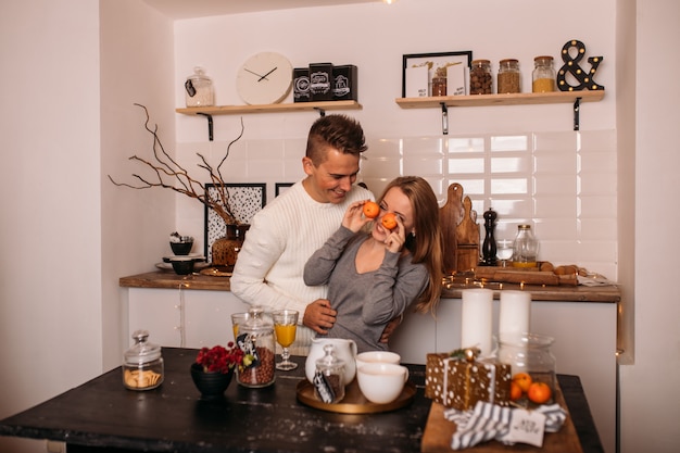 Giovani coppie nell'amore che ridono e che celebrano il natale nella cucina