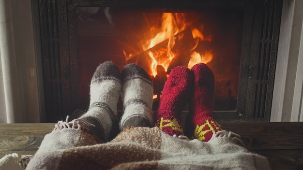 Young couple in love lying under blanket by the fireplace