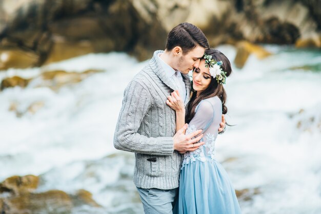 Young couple in love on a mountain river in the Carpathian mountains