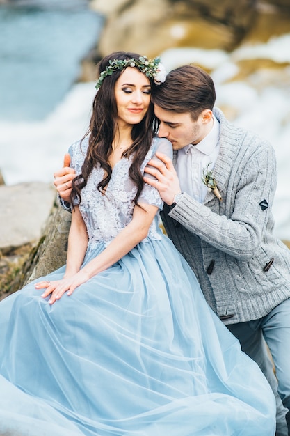 Young couple in love on a mountain river in the Carpathian mountains