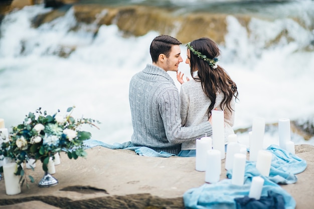 Young couple in love on a mountain river in the Carpathian mountains