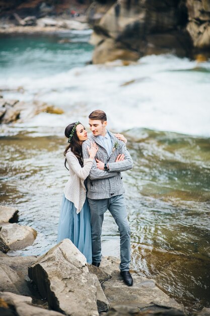 Young couple in love on a mountain river in the Carpathian mountains