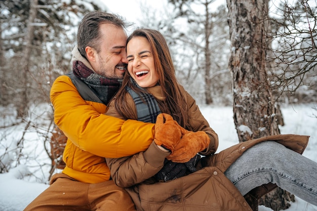 Young couple in love outdoor in snowy winter forest