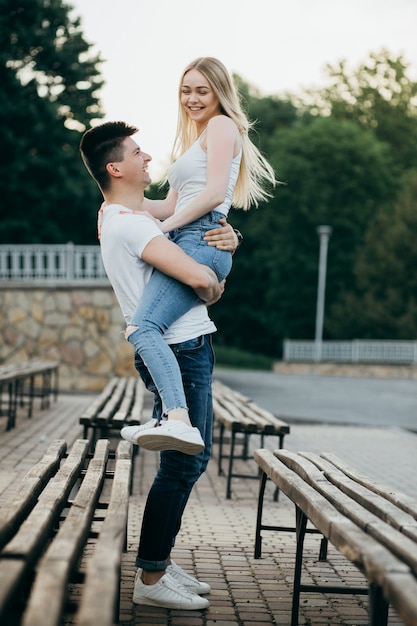 A young couple in love posing on the bench in the park