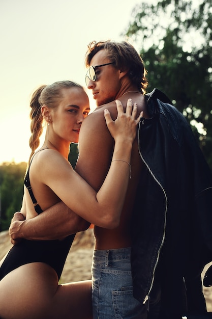 Young couple in love, riding a motorcycle, hugs, passion, free spirit, vintage, hipster, romantic, honey moon, cool outfit, modern style, rock, sexy denim sunglasses true run away