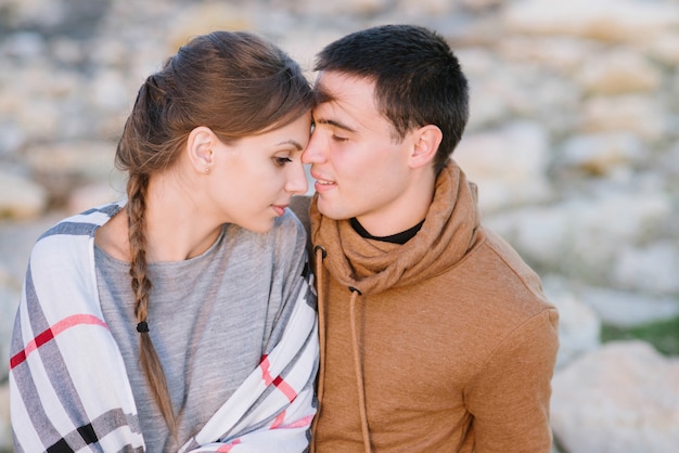 Young couple in love on a rocky beach