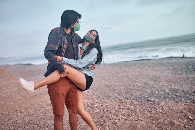 Young couple in love sitting on the beach during a beautiful sunset