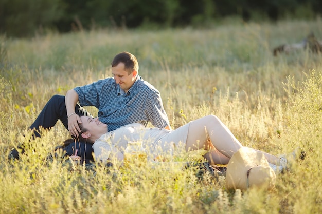 ピクニックに座って自然の中で一日を楽しんでいる愛の若いカップル