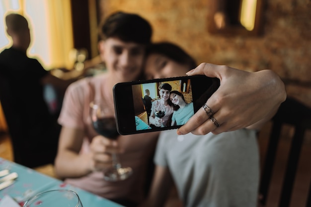 Foto giovane coppia innamorata che prende un selfie al loro appuntamento - giovane coppia seduta in un ristorante.