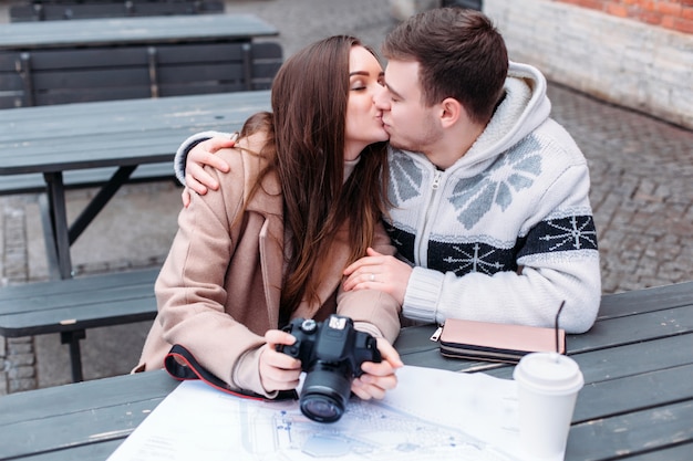 La giovane coppia in amore viaggia e bacia all'aperto in tempo freddo dell'inverno