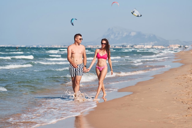 Giovani coppie nell'amore che cammina sulla spiaggia.