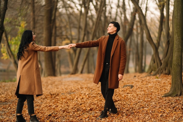 가을 날에 공원에서 산책하는 사랑에 젊은 부부