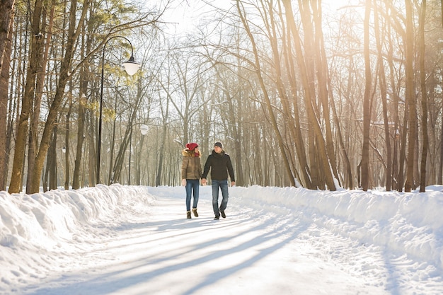 Young couple in love walking in the snowy forest.