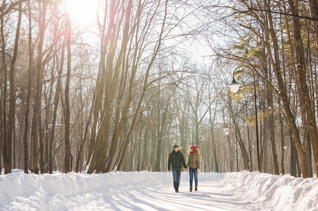 Young couple in love walking in the snowy forest.