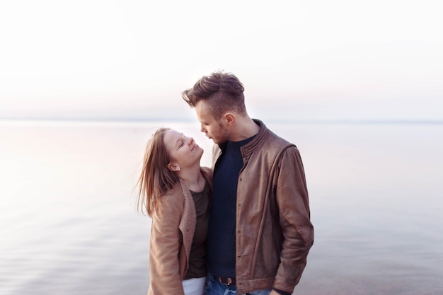 a young couple in love walks along the embankment at sunset