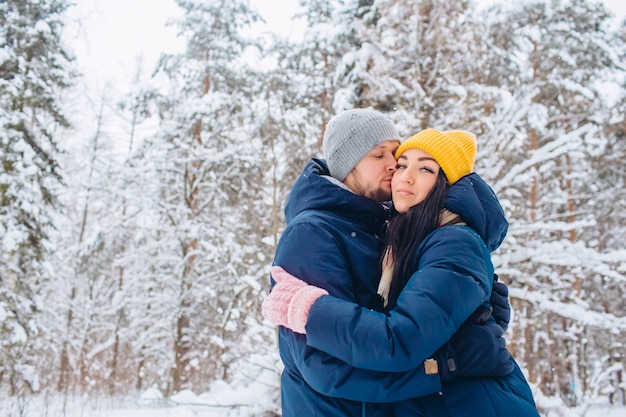 Young couple in love walks in the winter forest