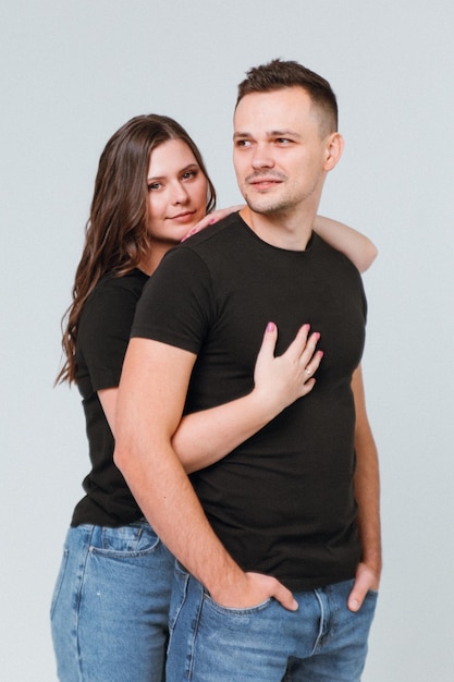 A young couple in love on a white background holding hands and hugging