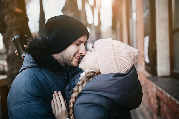Giovane coppia innamorata in abiti invernali che passeggiano per la città per un appuntamento