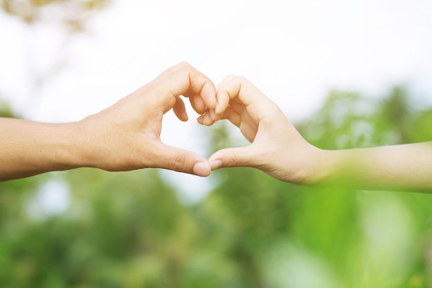 Young couple lover show holding hands make heart shape