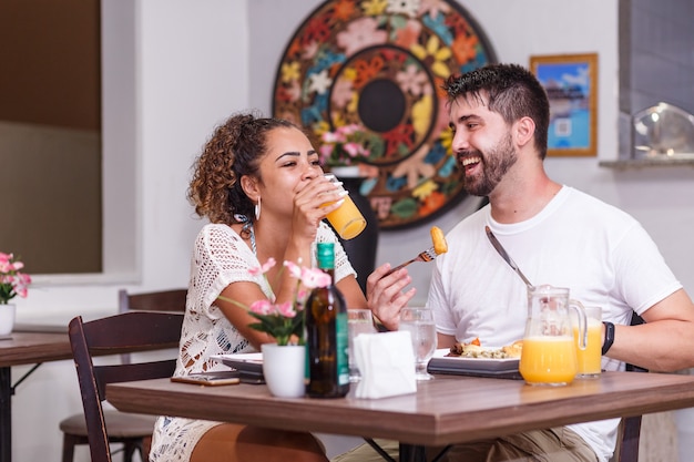 レストランで夕食を食べている恋人の若いカップル。