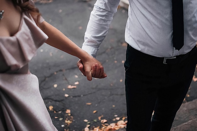 Young couple of lovers hold hands tightly