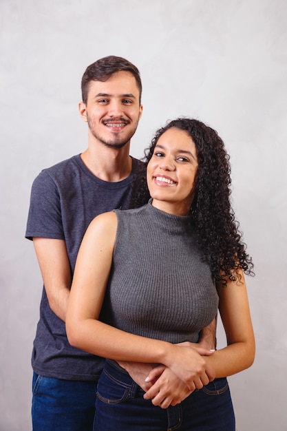 Photo young couple of lovers in love on gray wall.