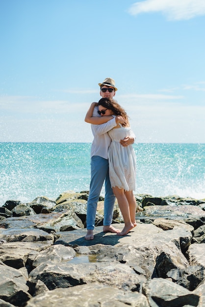 Photo a young couple of lovers in white clothes on the stones