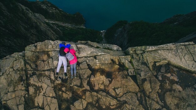 젊은 부부는 절벽의 가장자리에 누워. 피오르드 Lysefjord- 노르웨이-자연과 여행 배경에서 절벽 Preikestolen