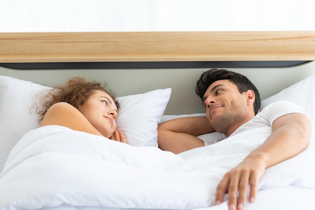 写真 ベッドに横たわっている若いカップル