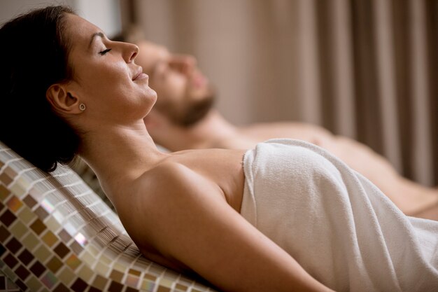 Young couple lying on the tepidarium beds