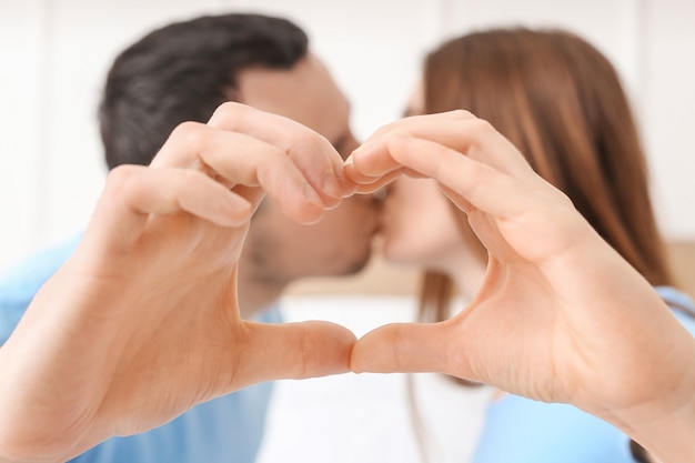 Young couple making heart shape with their hands, closeup