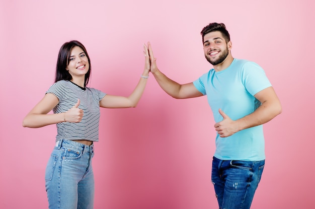 Young couple man and woman giving high five to each other