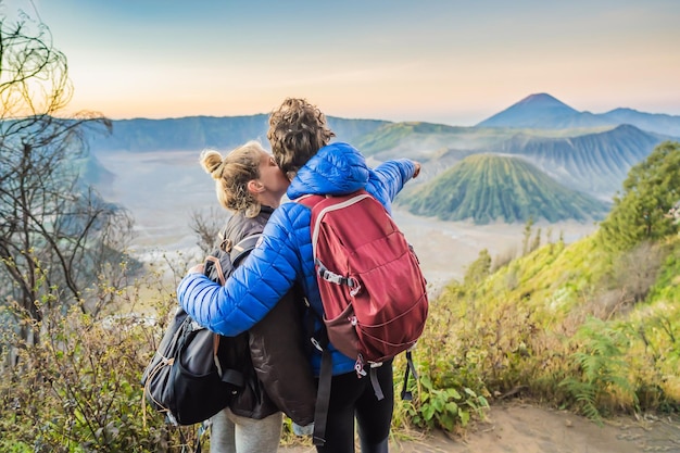 Young couple man and woman meet the sunrise at the bromo tengger semeru national park on the java