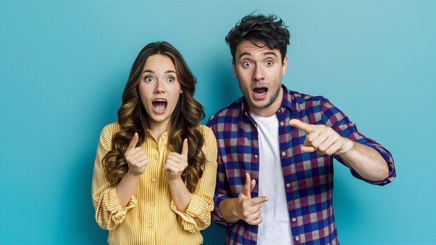 Young couple man and woman surprised pointing at copyspace