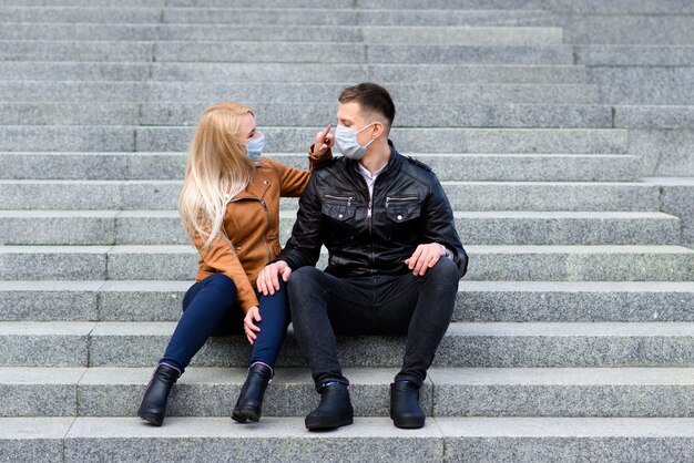 Young couple in masks on city street. Isolation, quarantine.