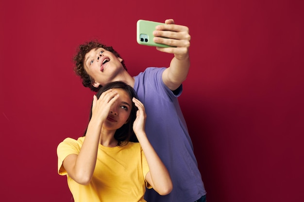 A young couple modern style emotions fun phone red background