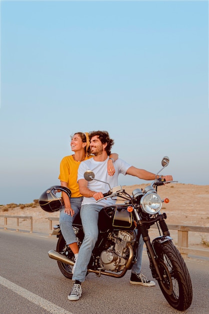 Young couple on motorcycle on a road traveling to the beach