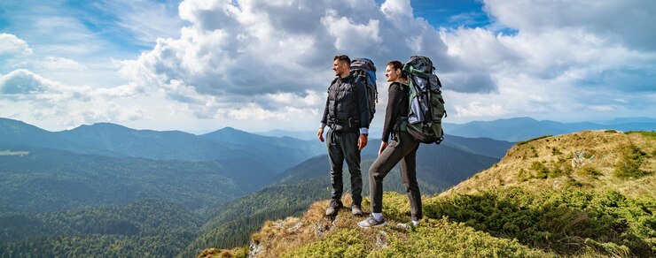 絵のように美しい雲景の背景に山の若いカップル