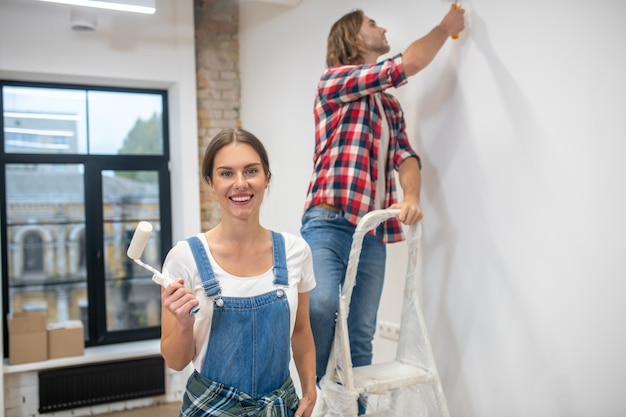 Young couple painting a wall and feeling good