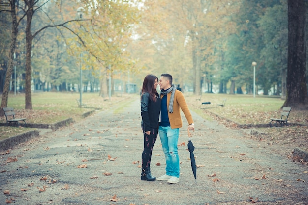 屋外の秋の季節に公園の若いカップル