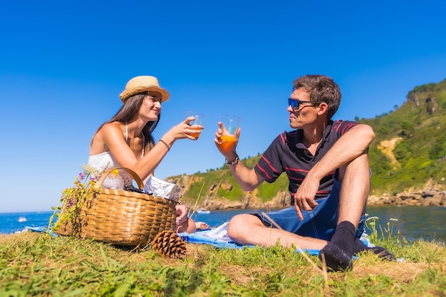 A young couple on a picnic in the mountains by the sea enjoying the summer