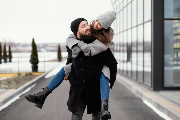 Young couple piggy back ride walk