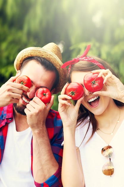 young couple planting organic tomatoes