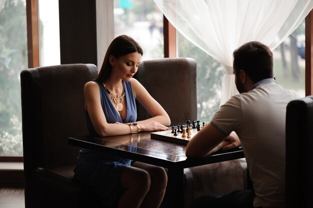 Young couple playing chess in the restaurant