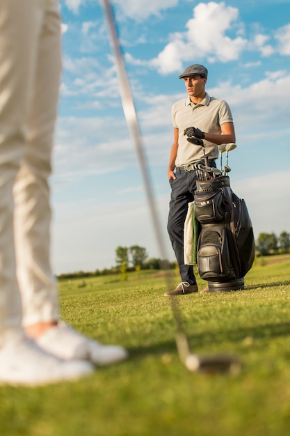 Giovane coppia giocando a golf