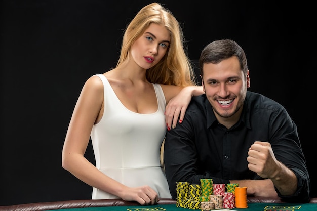 Young couple playing poker and have good time in casino